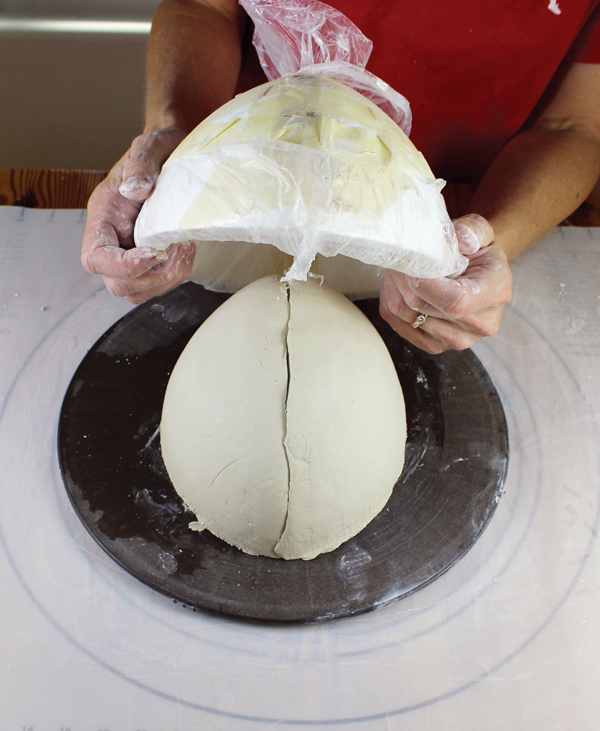 8 Place a bat or ware board over the wide opening of the mold, flip the bowl over. Remove the mold. Use a rib and gently smooth the seam of the bowl from rim to rim and then smooth the outside of the bowl.