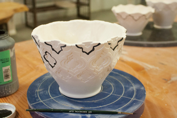 9 Add underglaze line work around the medium-sized stamps in the pattern. Choosing these shapes helps to accentuate the pattern without being too dominant after the glaze firing.