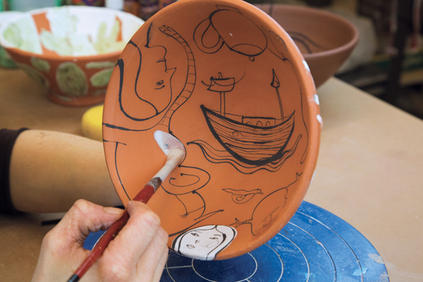 3 After the bisque firing, coat the images with clear glaze painted with a soft brush.
