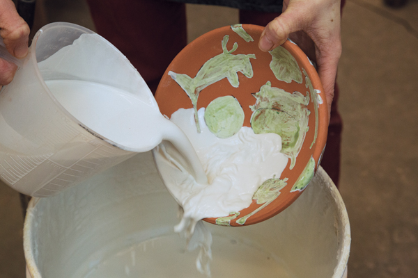 5 After the wax is dry, turquoise glaze is poured over about half the bowl.