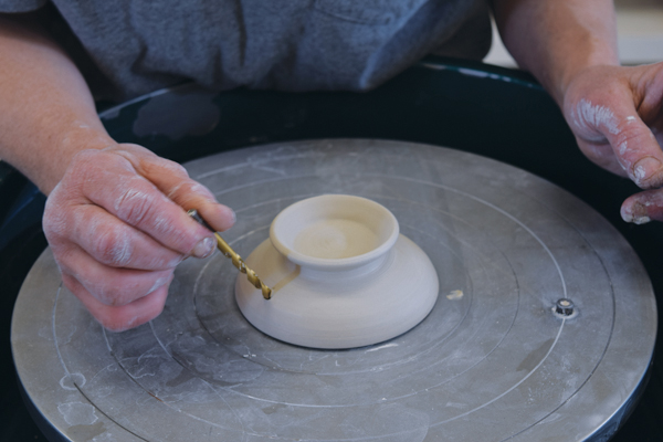 6 Use a drill bit to put a ¼-inch hole in the rim of the lid. Cut the excess clay from the end of the handle.