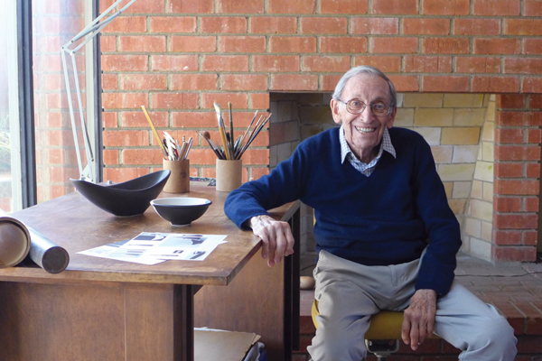 2 Jerome Ackerman, pictured at his drafting table with original Jenev pieces and catalogs, 2017. Courtesy of Ackerman Modern.