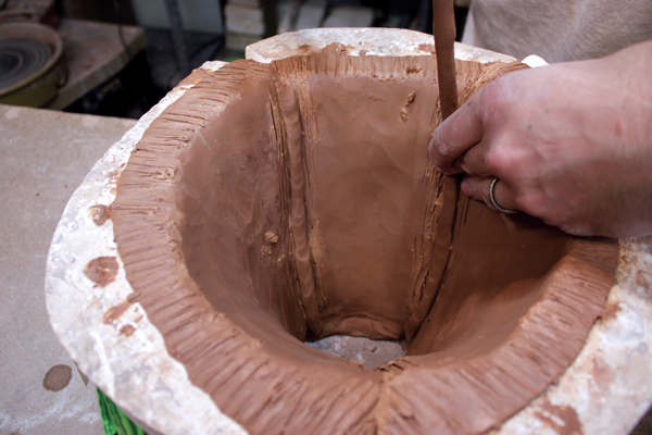 8 After fitting the top three mold sections together, press coils into each seam.