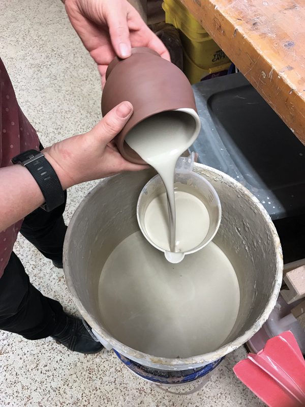 1 After throwing and trimming the cup, coat the interior with white slip, then pour out the excess.