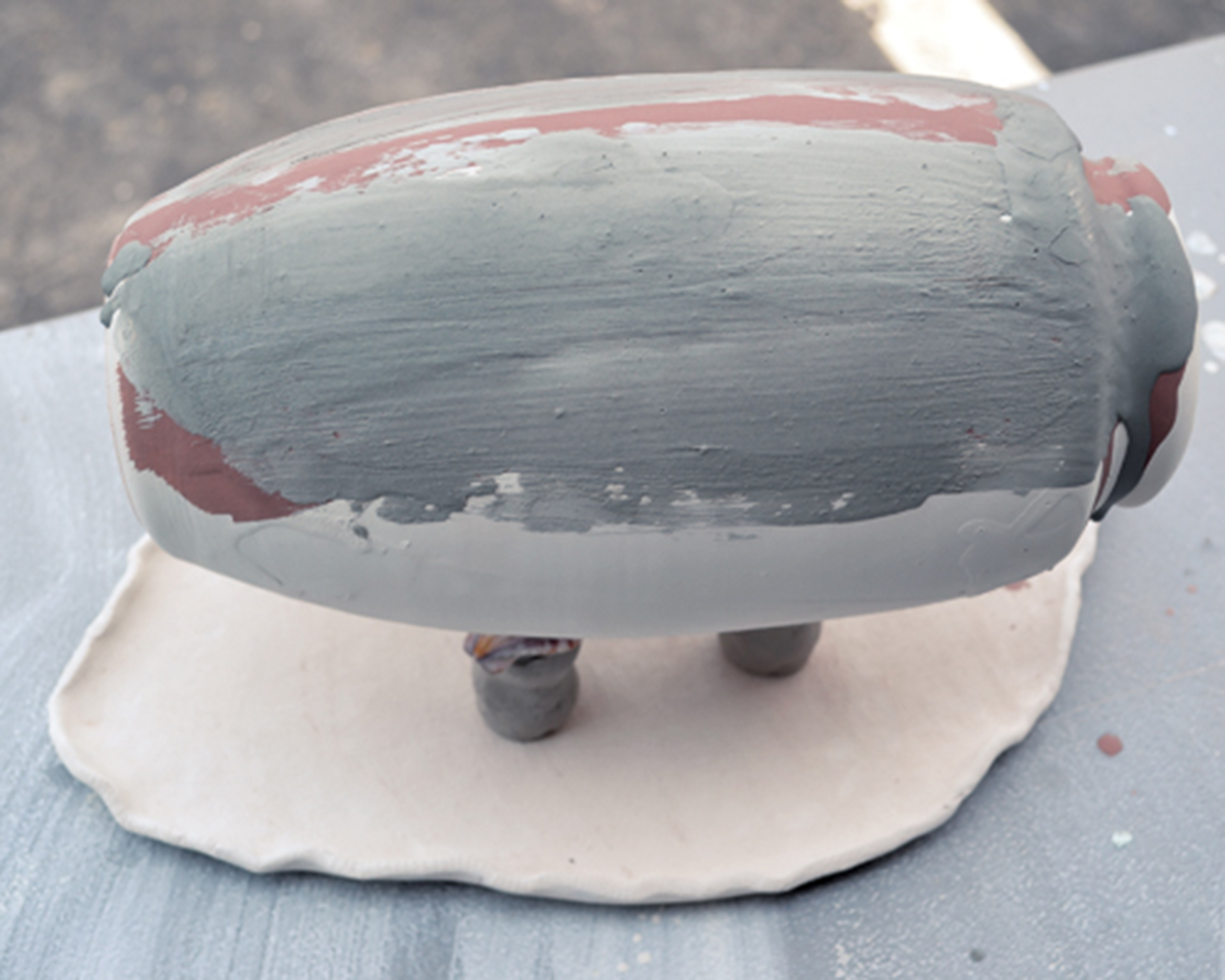 6 Brush the top-facing part of the pot (the side of the pot, but it’s now facing upward) with ash glazes. Use one or more ash glazes for different effects.