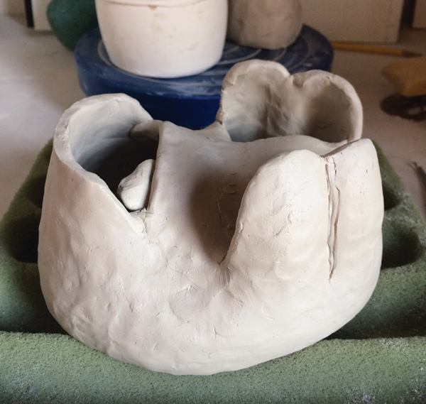 2 Form a pinch pot over the template, then remove it from the template when it can hold its own weight. Enclose the form by adding coils and slabs.