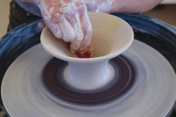 5 Open up the rest of the hump all the way to the bat and pull up a narrow-footed bowl. Using a rib, refine the form and widen the rim so it matches the gallery measurement.