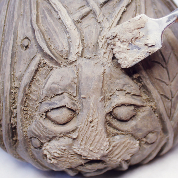5 Score and slip the carved design to attach small bits of clay to the high points of your design.