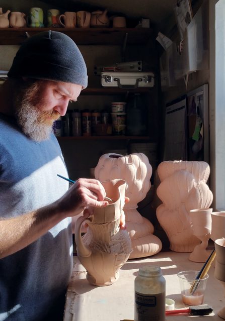 12 Waxing the mouth of a bisqued pitcher before slipping. Photo: Andrew Clark.