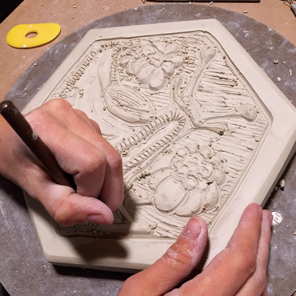 2 Jordan Jones, a visiting artist at Rat City Studios, carving a paver model.