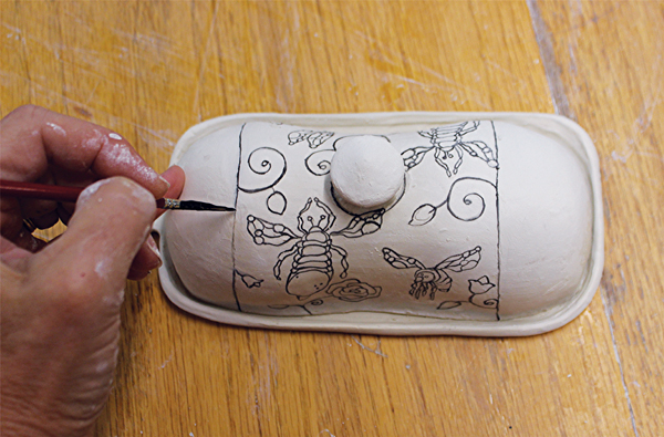10 Brush on underglaze over the hand-drawn images.