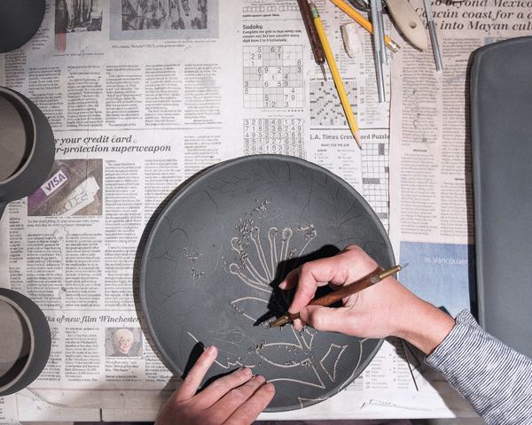 4 Continue to outline the drawn design or pattern. Once the clay shavings are dry, they can be cleared from the surface.