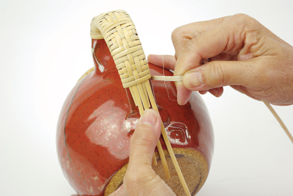 8 A completed teapot handle embellishment with a diamond-weave pattern repeated 3 times.