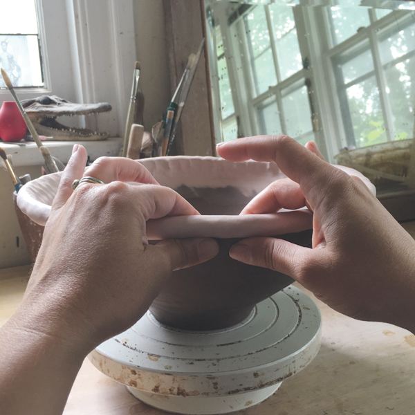 6 Pinch the clay under the coil to facilitate smoothing the outside rim downward.