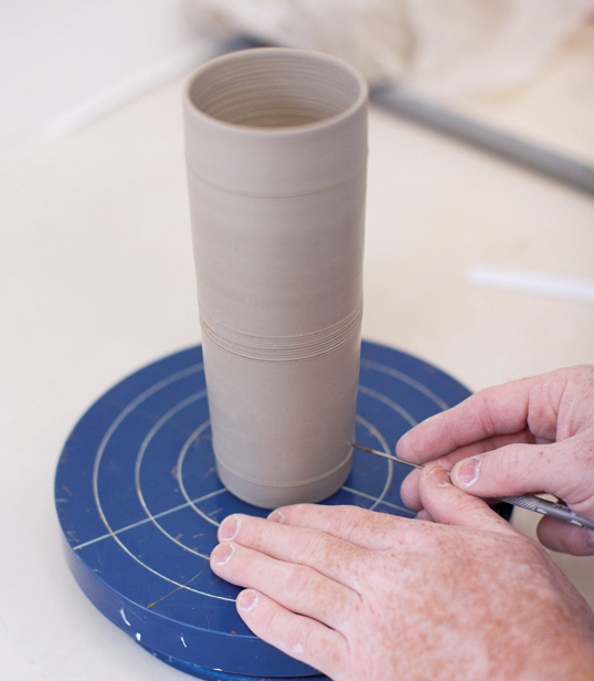 9 Using a banding wheel, divide the cup into six equal vertical sections.