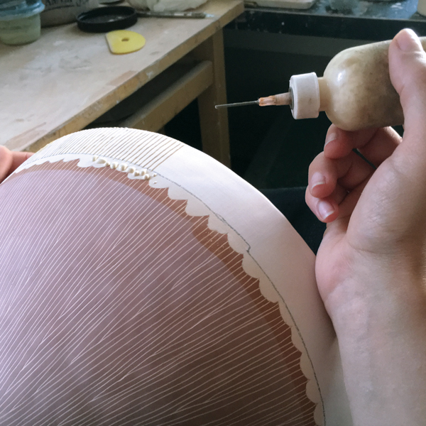 15 Trail undiluted wax lines onto the rim of the bisqued bowl prior to glazing to create a resist pattern.
