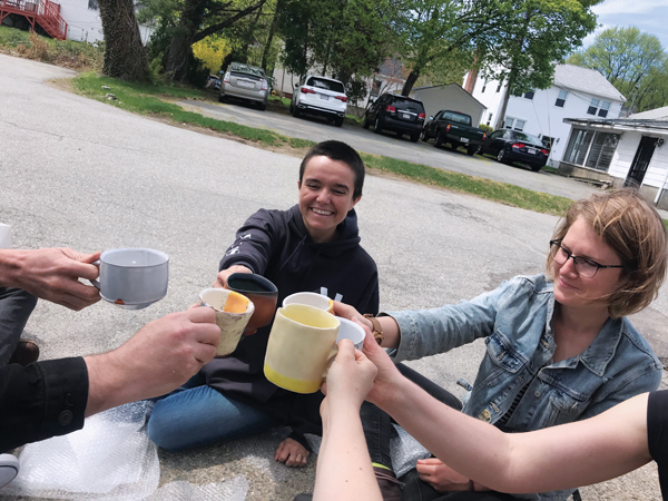 1 Participants in the Yankee swap group toasting one another with their new mugs after the Worcester Pottery Invitational in 2018.