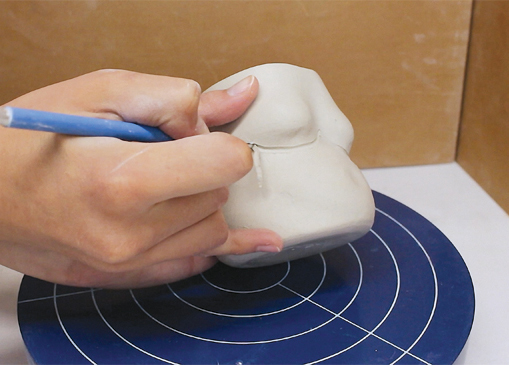 6 To define the body parts, carve lines throughout the piece.