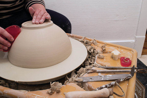 1 After trimming a bowl thrown from 6–8 pounds of clay, compress and smooth the surface using a soft rib. Make sure the walls are still malleable, then squeeze the bowl into an oval shape.