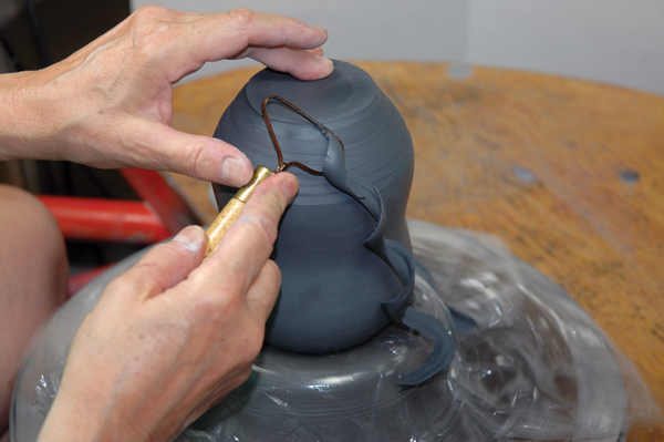 6 Center bottle on chuck. Hold steady from the top and trim the lower wall and base.