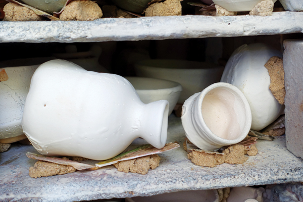 13 View of the kiln being loaded with work propped up on wadding and seashells.