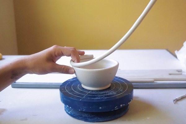 2 Add the coil to the rim using your other hand to guide its placement.