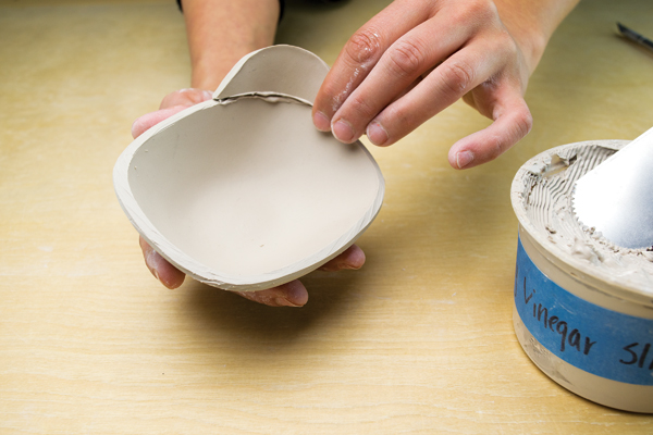 7 Slip and score the handle onto the rim, compressing the seam on both sides.