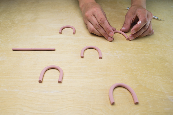 10 Extrude colored porcelain coils, cut, and immediately curve into arch shapes.