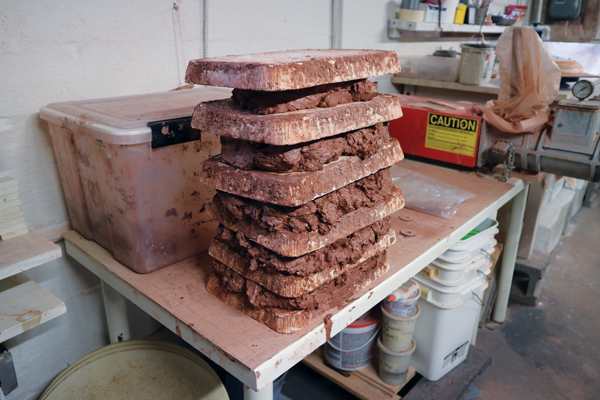 4 The slop is dried out to a workable consistency by stacking it between plaster slabs. 