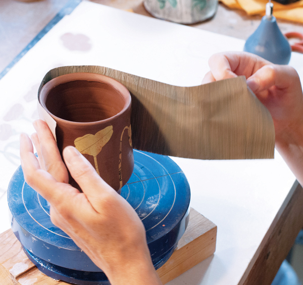 3 Wrap newsprint coated in the background slip around the cup.