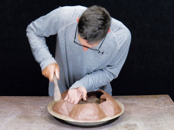 2 Paddle the coils to compress, thin, and shape them while supporting the interior with your other hand to maintain the shape.