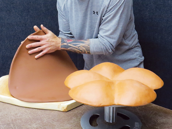 5 Roll out a 1/2-inch-thick slab and drape it over the bisque-fired platter mold that’s placed on a banding wheel.
