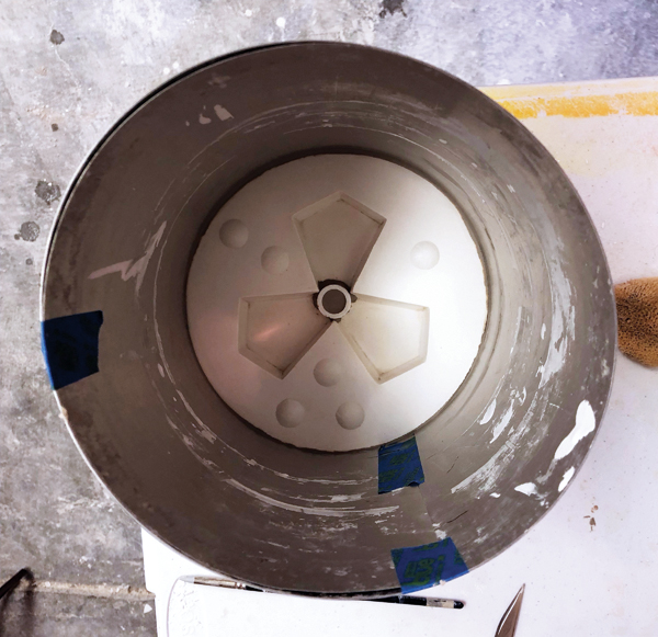 11 Place the PVC pipe in the pour hole with 1/4 inch of it inserted into the negative space of the mold. Pour plaster onto the second mold part to create a mother mold.