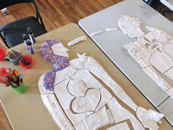 3 Underglazing bisque-fired tiles made by Syrian newcomer and French Immersion elementary students in London, Ontario.
