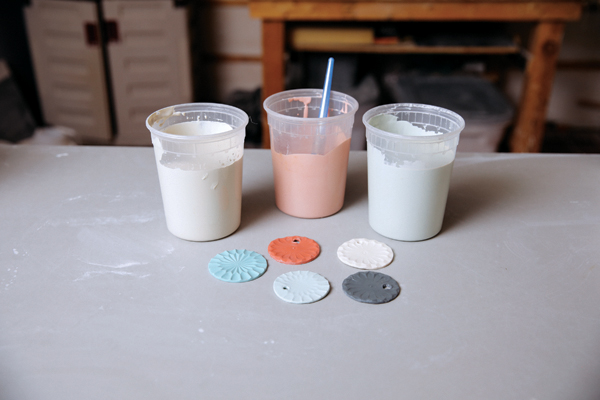 2 Select the vase’s color palette: fired color samples and colored porcelain casting slip in dark gray, turquoise, red, and light blue.