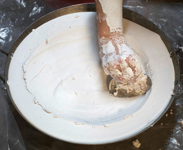 2 Use a metal rib to remove extra plaster from the bottom of the mold. 1, 2 Photos: Sharon Davis.