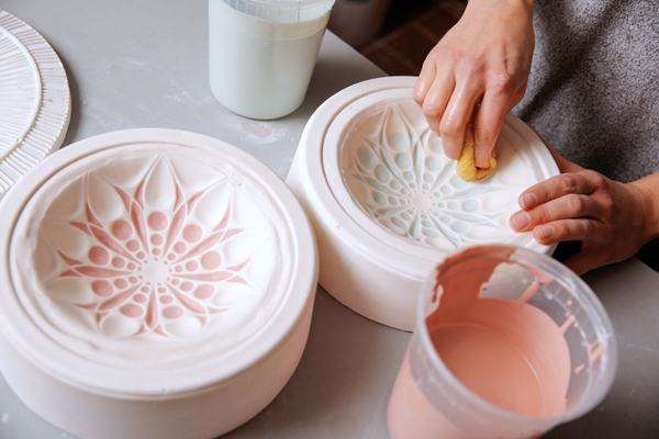 4 Wipe away excess slip. The slip will stay in the recessed areas of the pattern mold.