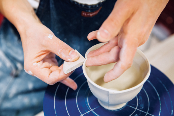 7 Make a second pass using the wooden triangle rib, placing your index and middle finger on the inside of the cup.