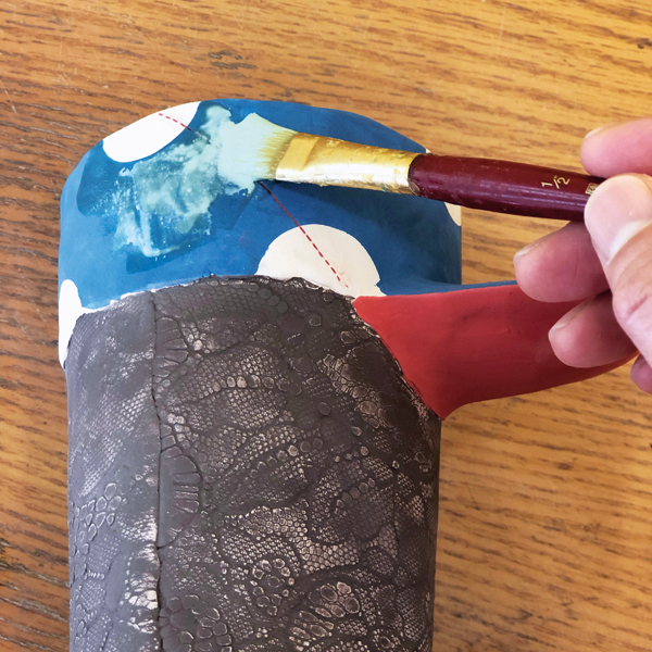 13 Apply wax resist to the underglaze colored area, then glaze to create contrast.
