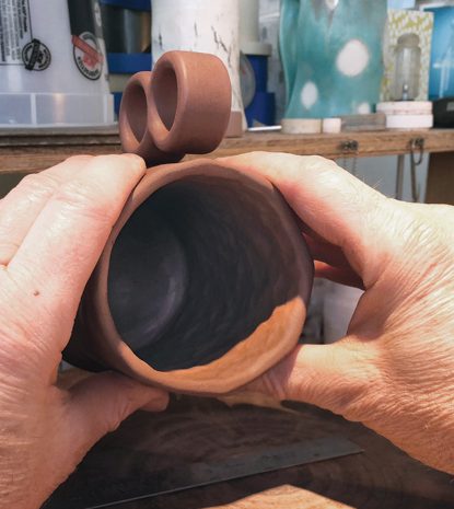 12 Squeeze the mug into an oval. It will return to cylindrical as it dries and fires.