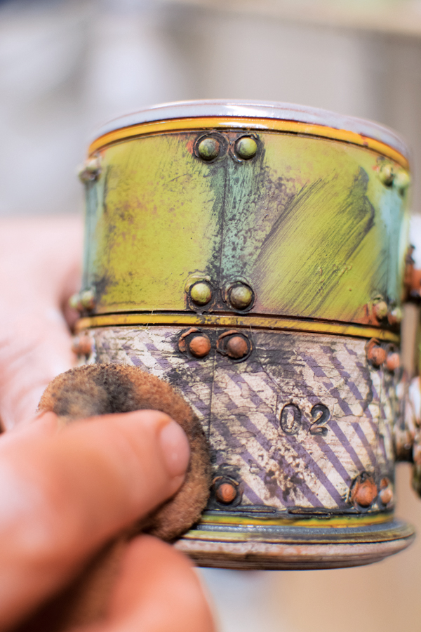 14 Apply black copper oxide wash to the bisque-fired piece, then wipe it away.