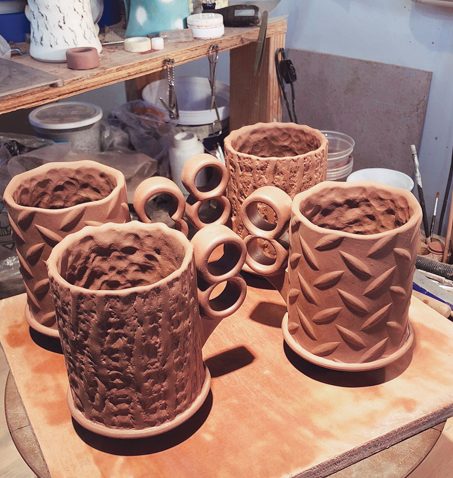 Finished mugs ready to dry evenly under plastic for a day or two.