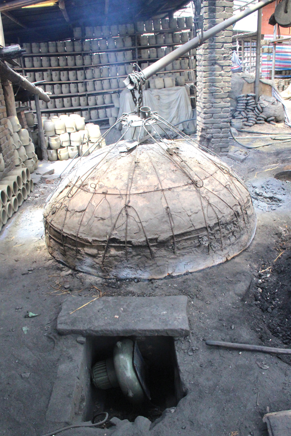 5 The forced air machine can be seen in the foreground. Clay smeared onto a metal rod dome forms the kiln’s wok cover.