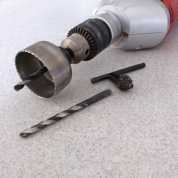4 A 2 and 1/8-inch hole saw, 1/4-inch drill bit, and electric drill.