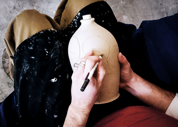 1 Draw the imagery onto the surface of the leather-hard pot. I use a ball point pen that no longer works.