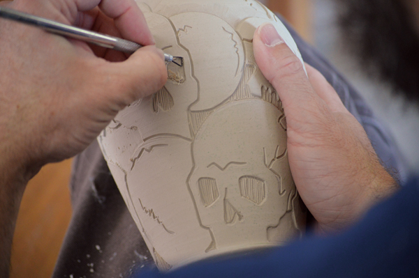 4 Using a flat-edged carving tool, begin to remove clay from the areas that will have the deepest relief.