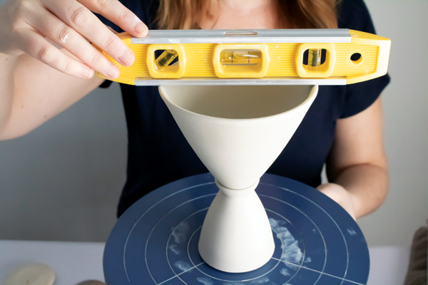 5 Slip, score, and attach the stem and cup, checking the alignment with a level.