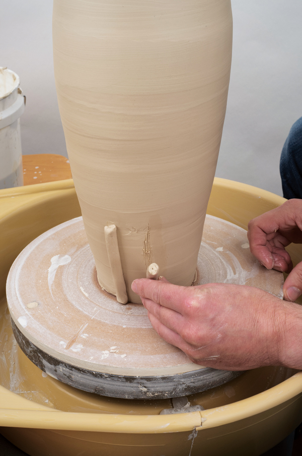 5 Lightly score, wet with thin slip, and apply the first coil vertically so the bottom of the coil touches your bat.