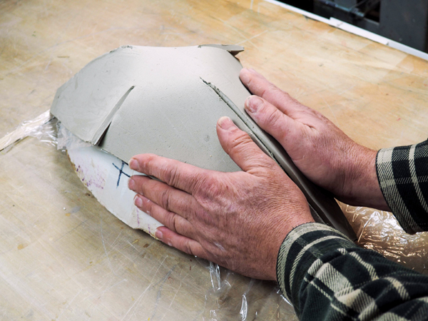 8 Press the seams together with your hands, being sure to lift the clay away from the plastic wrap first.