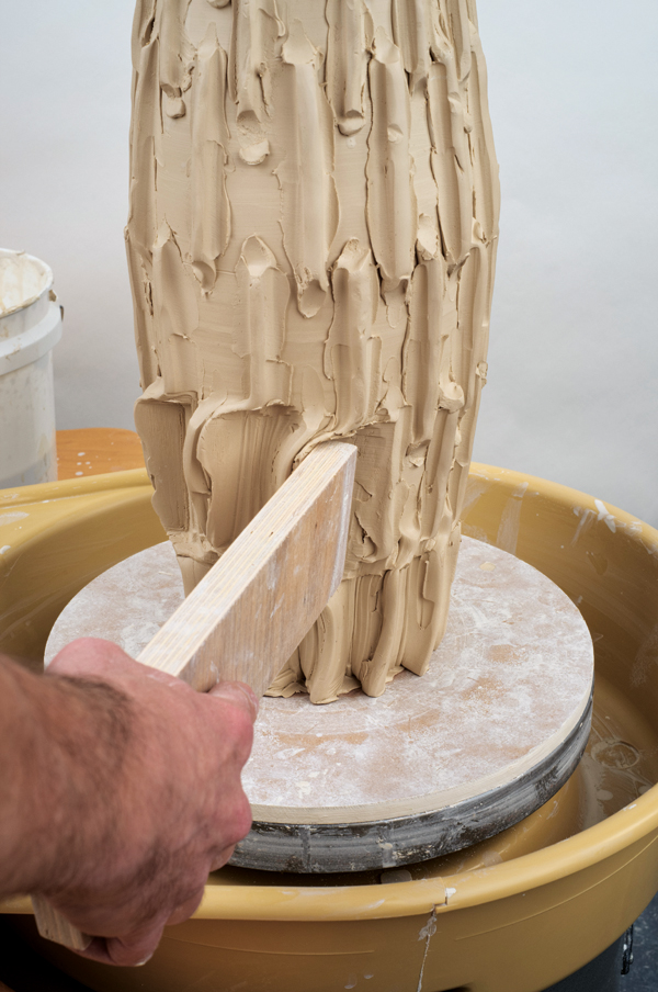 10 Paddle along the surface of the cylinder moving the clay into each coil, then moving the coil slightly along the surface.
